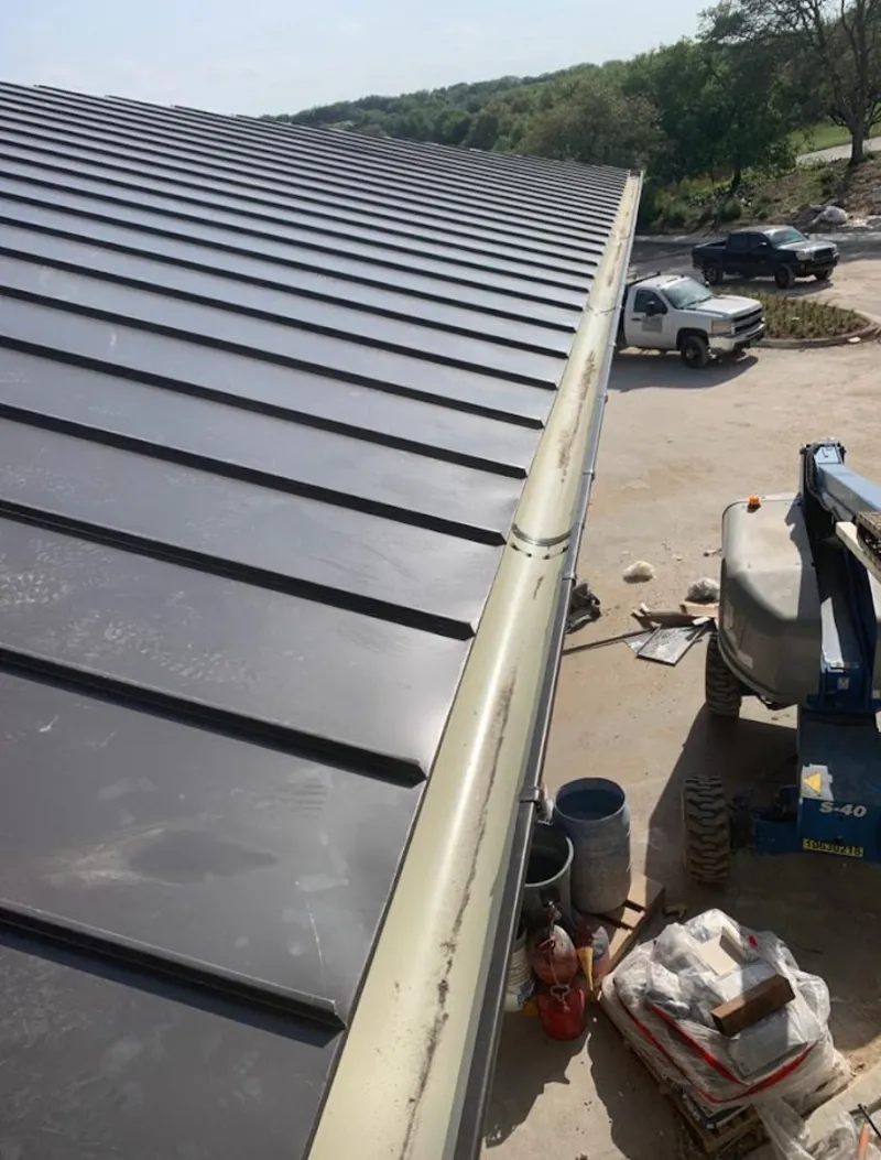 Standing seam panel and gutter detail on a metal roofing jobsite in Homewood